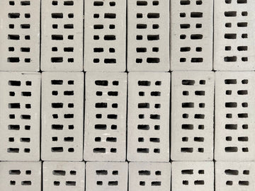 White bricks with rectangular holes are stacked.